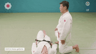 ushiro-kesa-gatame - A technique to hold down the opponent’s upper body under the left side of the chest region by putting the left hip on the right side of his body from the right side of the opponent lying on his back, holding his right arm in the right arm and holding his upper body in the left arm. ushiro-kesa-gatame - A technique to hold down the opponent’s upper body under the left side of the chest region by putting the left hip on the right side of his body from the right side of the opponent lying on his back, holding his right arm in the right arm and holding his upper body in the left arm.